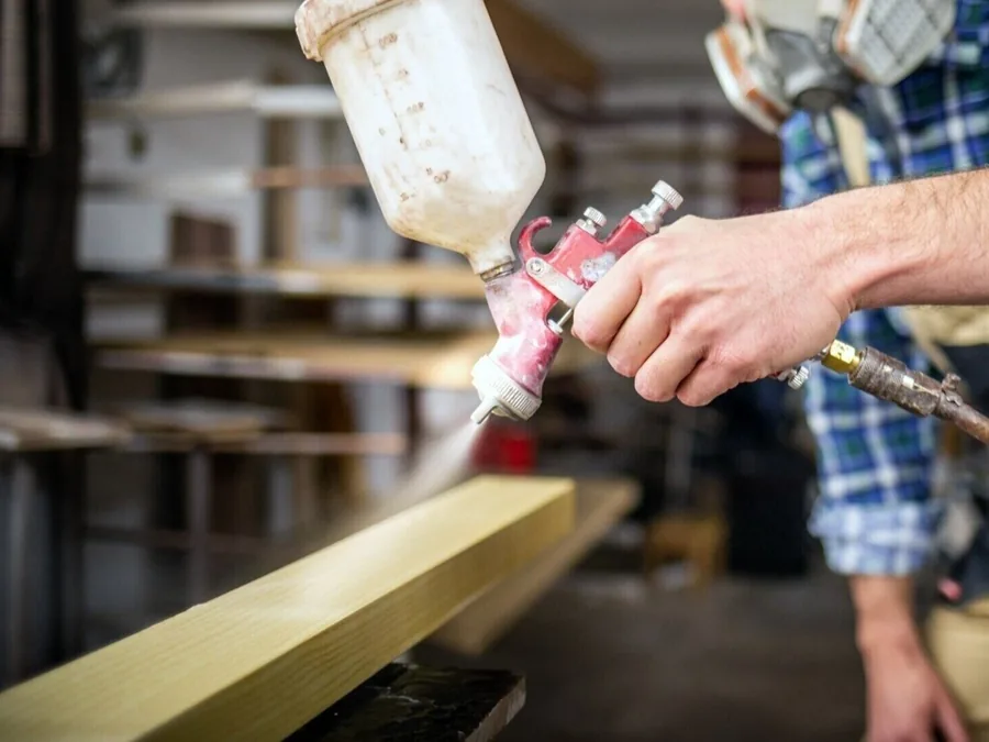 Spray finishing a wood panel in the Classic Wood Finishing shop